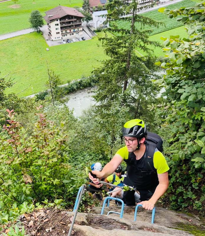 Mann mit Helm beim Klettern an einem Klettersteig