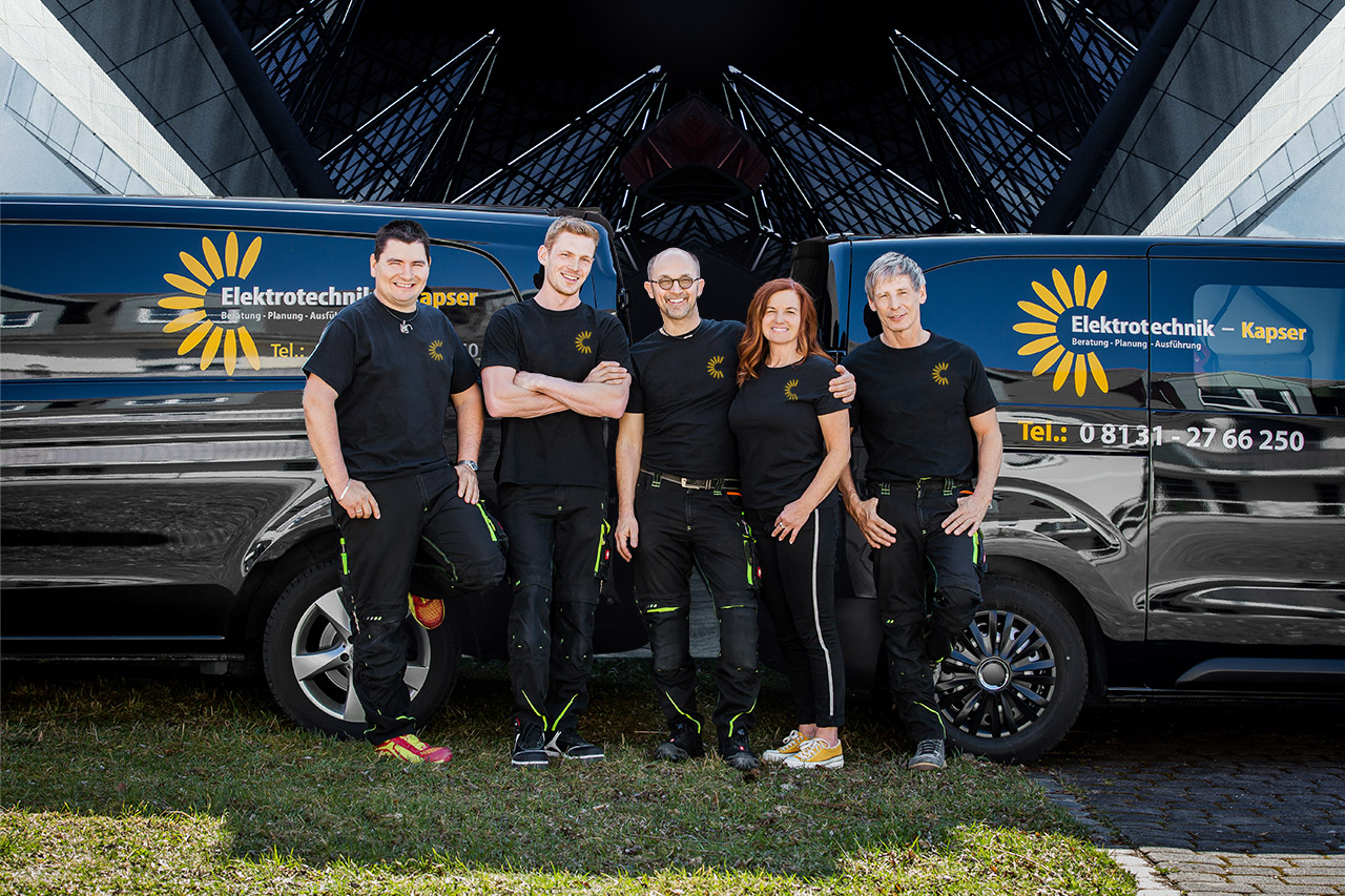 Das Team von Elektrotechnik Kapser vor zwei Firmentransportern