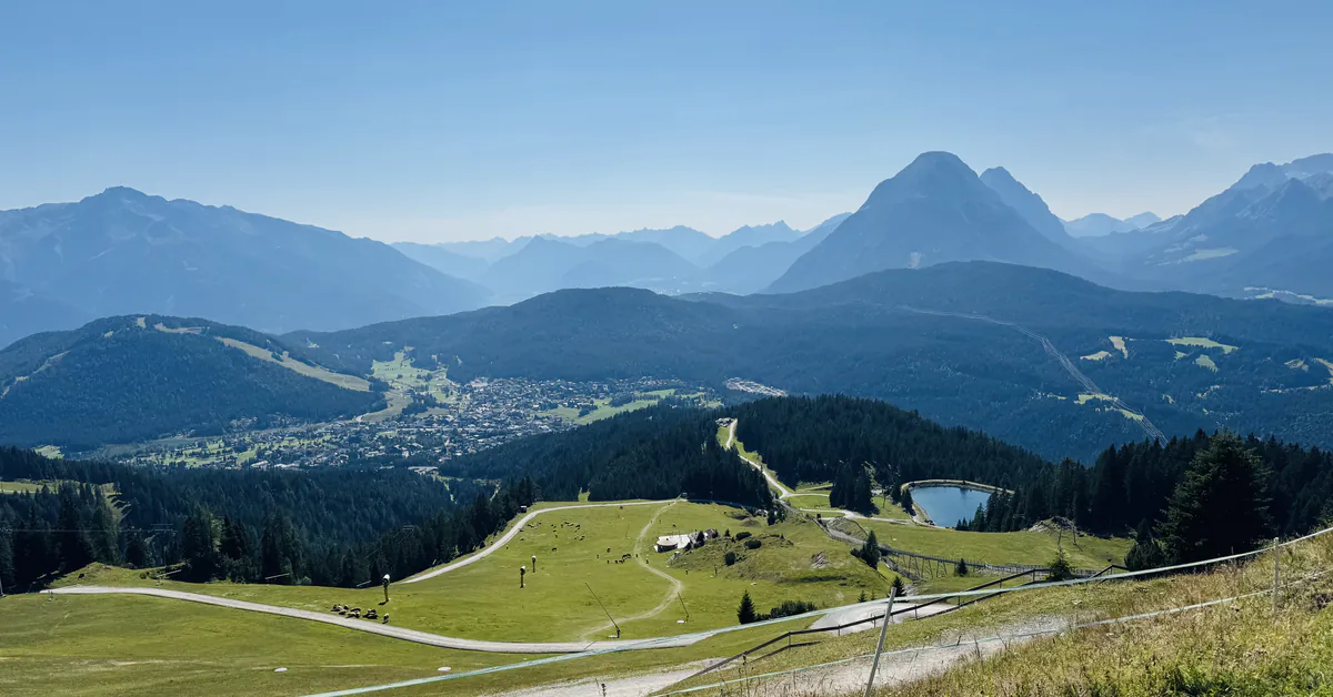 Panoramablick über ein Hochplateau mit Bergsee und Gipfeln