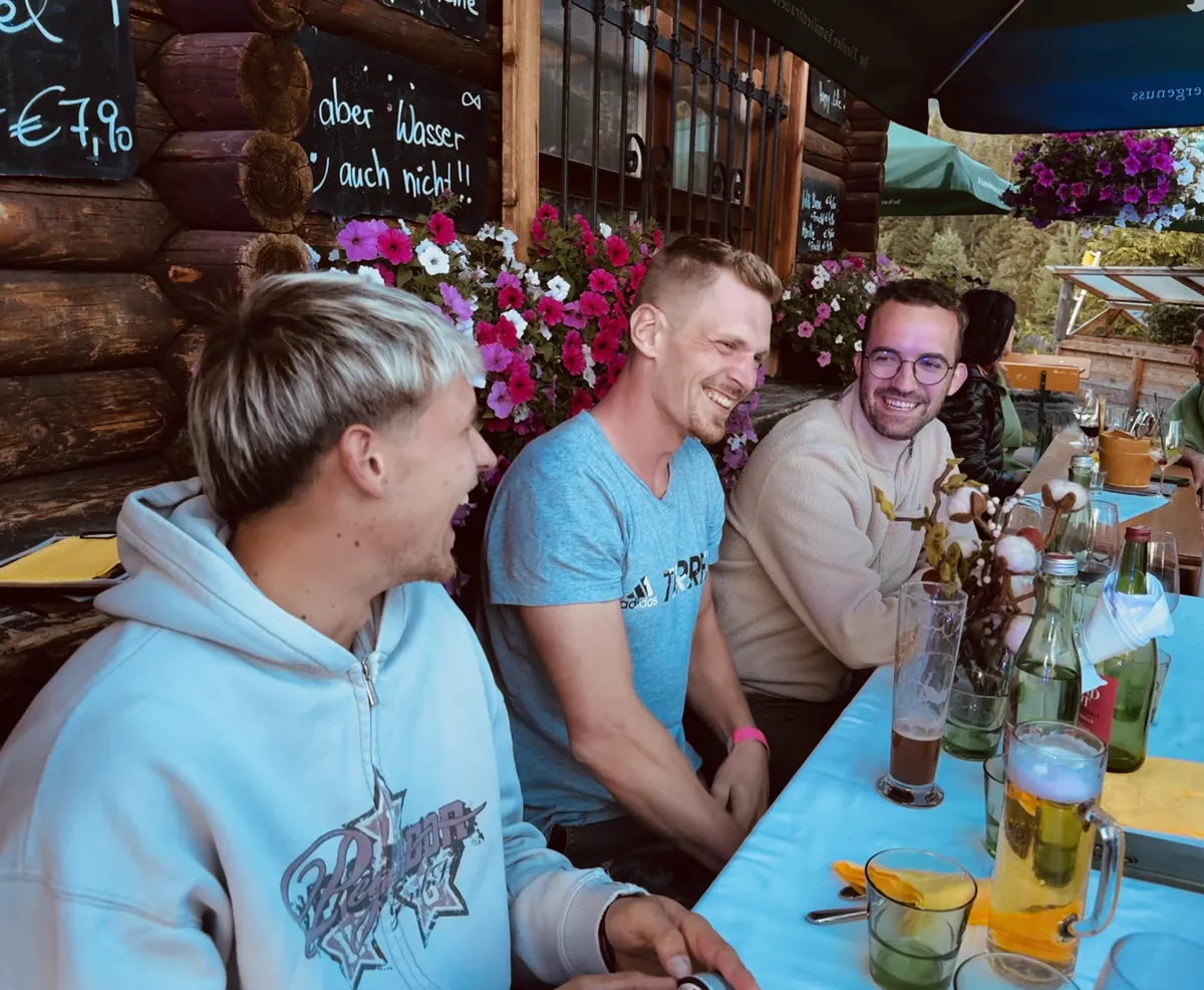Drei Kollegen stoßen am gedeckten Tisch an