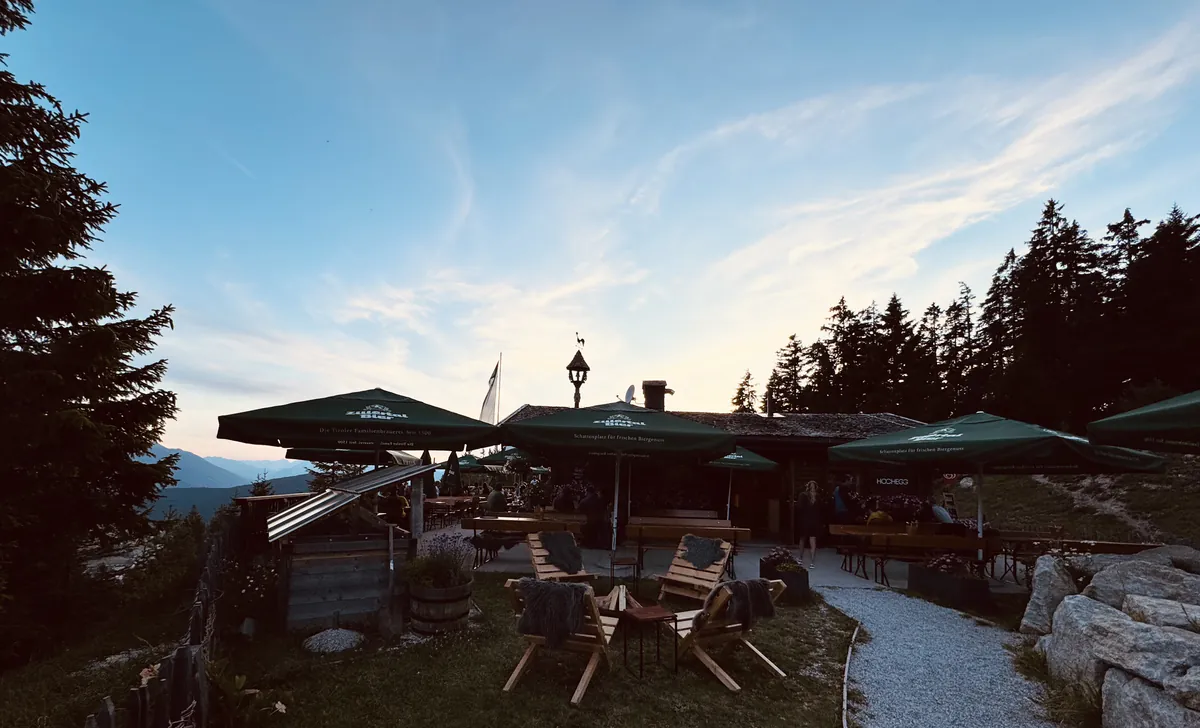 Almterrasse mit Sonnenschirmen in der Dämmerung