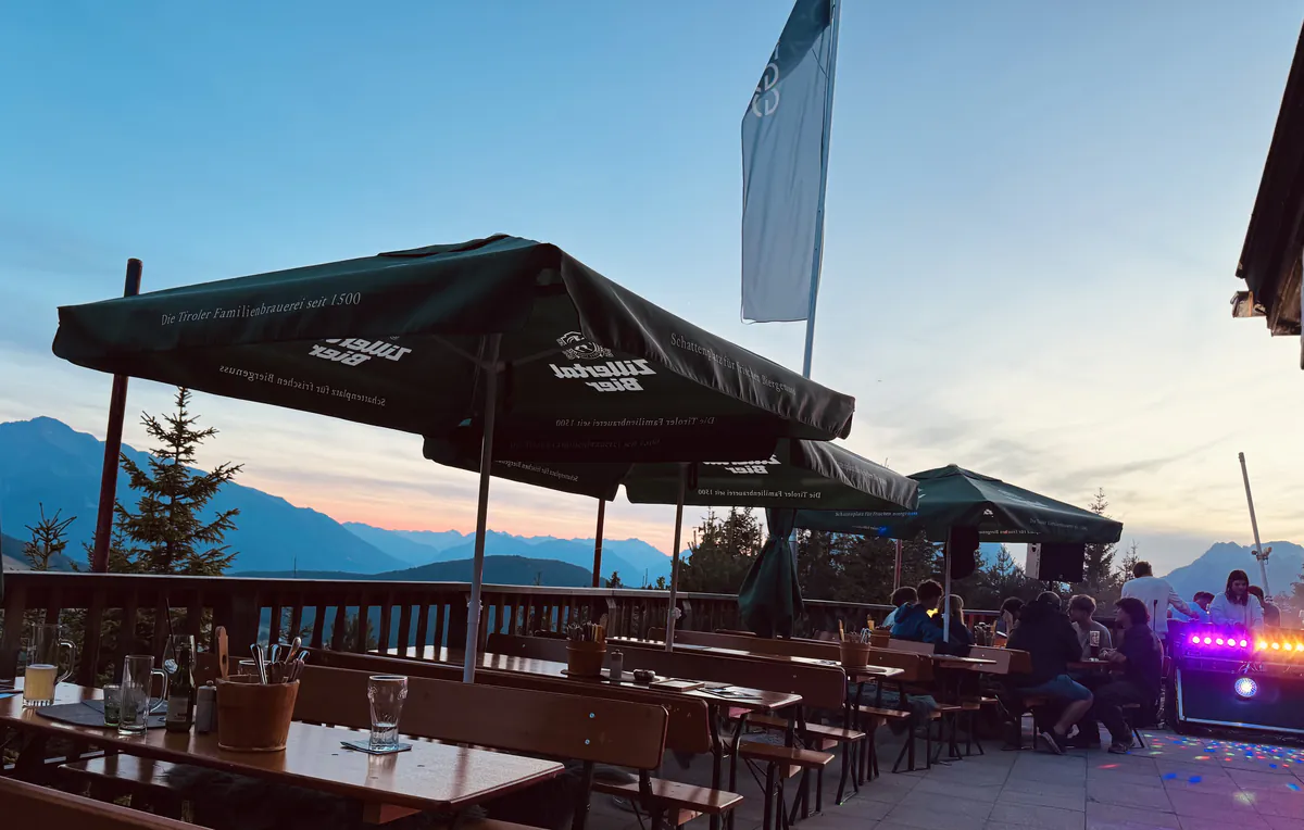 Almterrasse mit Sonnenschirmen im Abendlicht